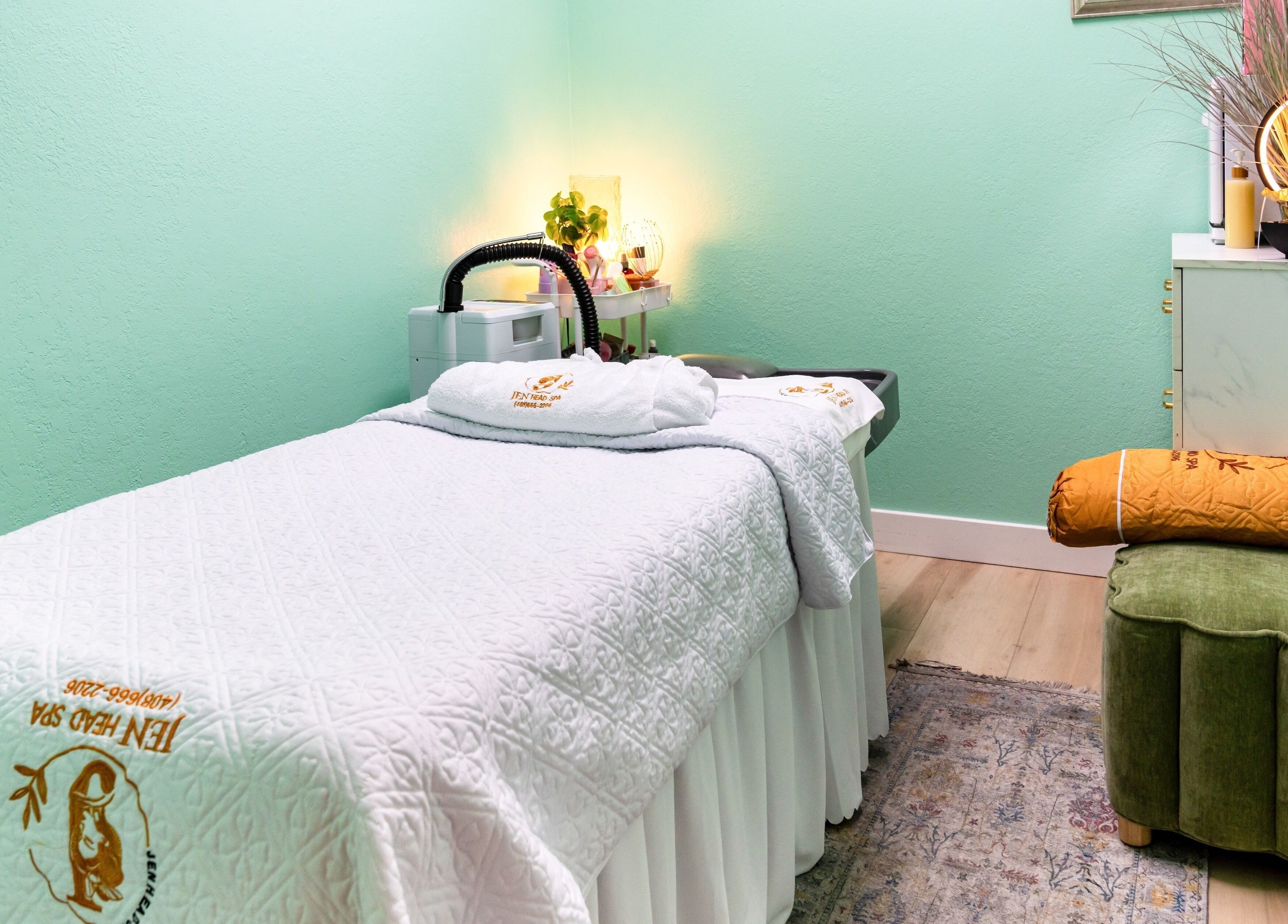 Tranquil treatment room at Jen Head Spa in San Jose, California, US with plush bed and soft lighting.