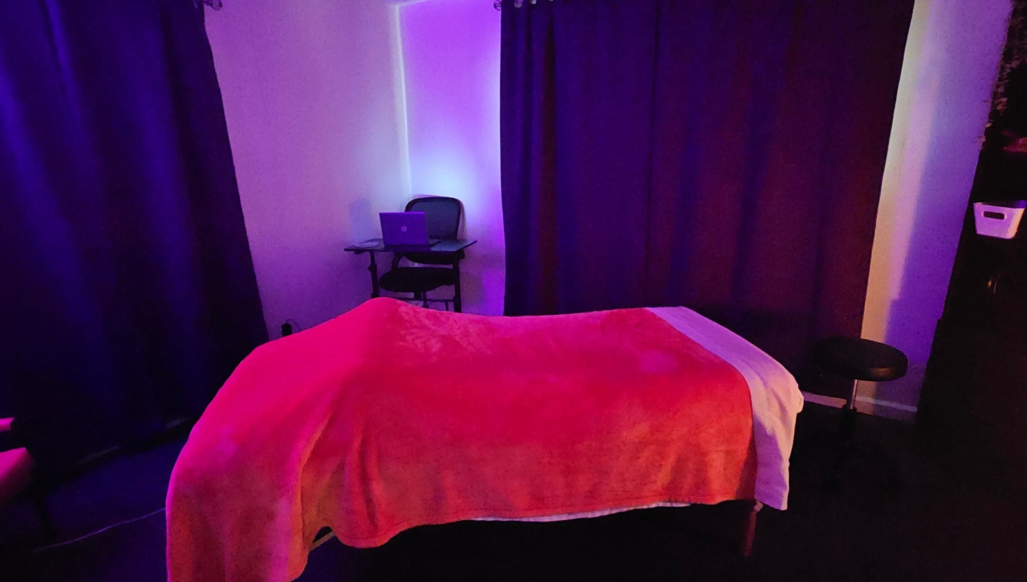 Soothing massage room at Sherna's Synchronicities, LLC, California, Maryland, US with calming purple and red tones.