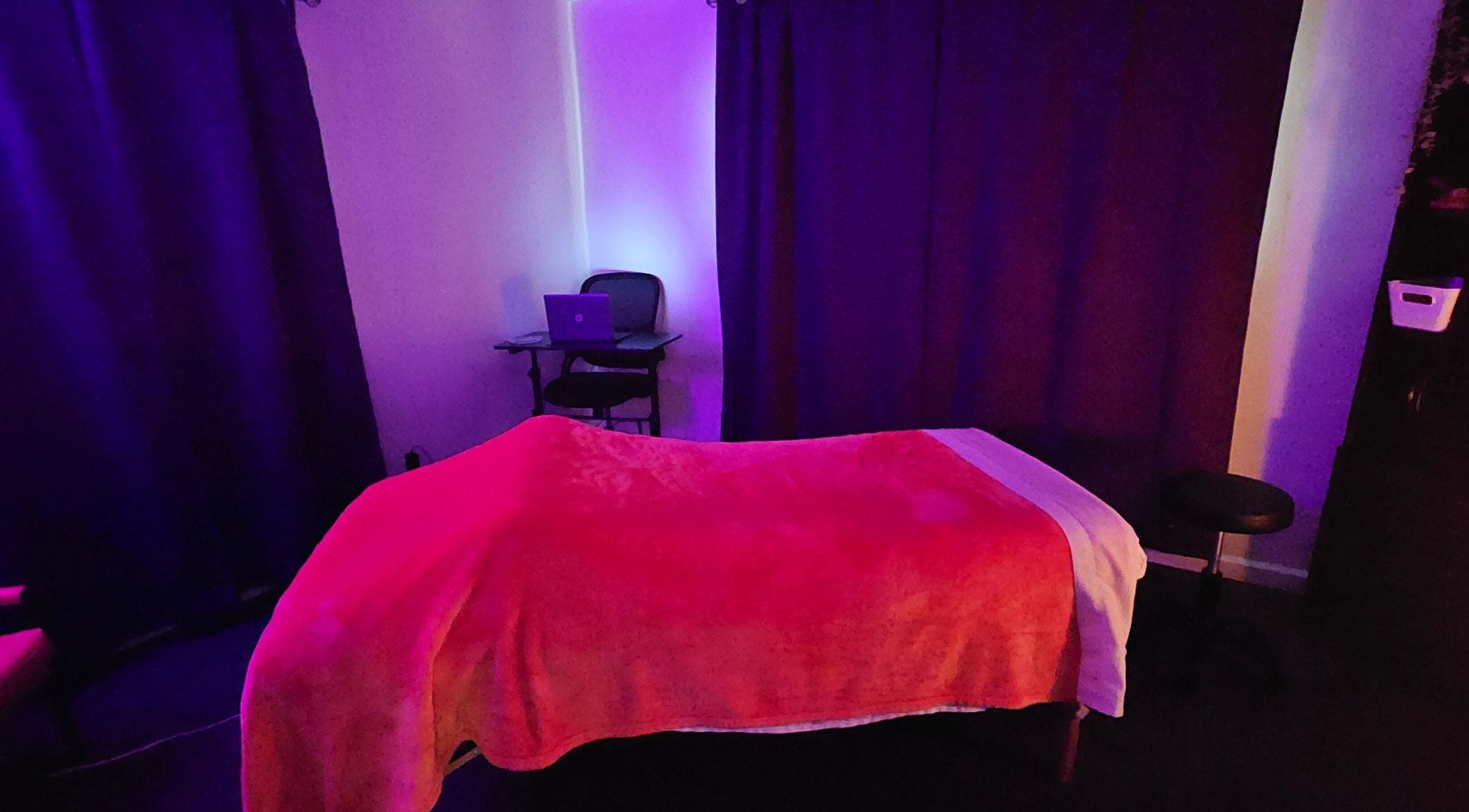 Soothing massage room at Sherna's Synchronicities, LLC, California, Maryland, US with calming purple and red tones.
