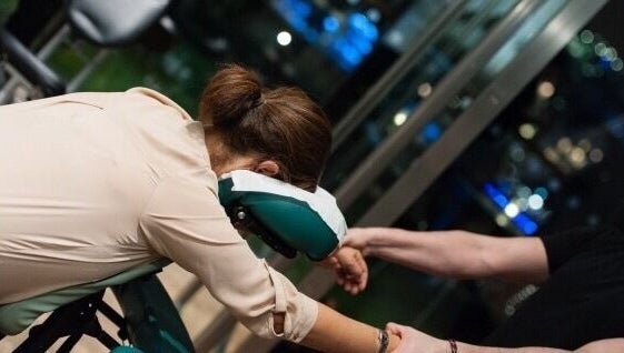 Person receiving a relaxing chair massage at X + Why Members - Fivefeids' Victoria, London, England, GB.