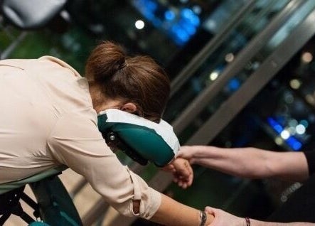 Person receiving a relaxing chair massage at X + Why Members - Fivefeids' Victoria, London, England, GB.