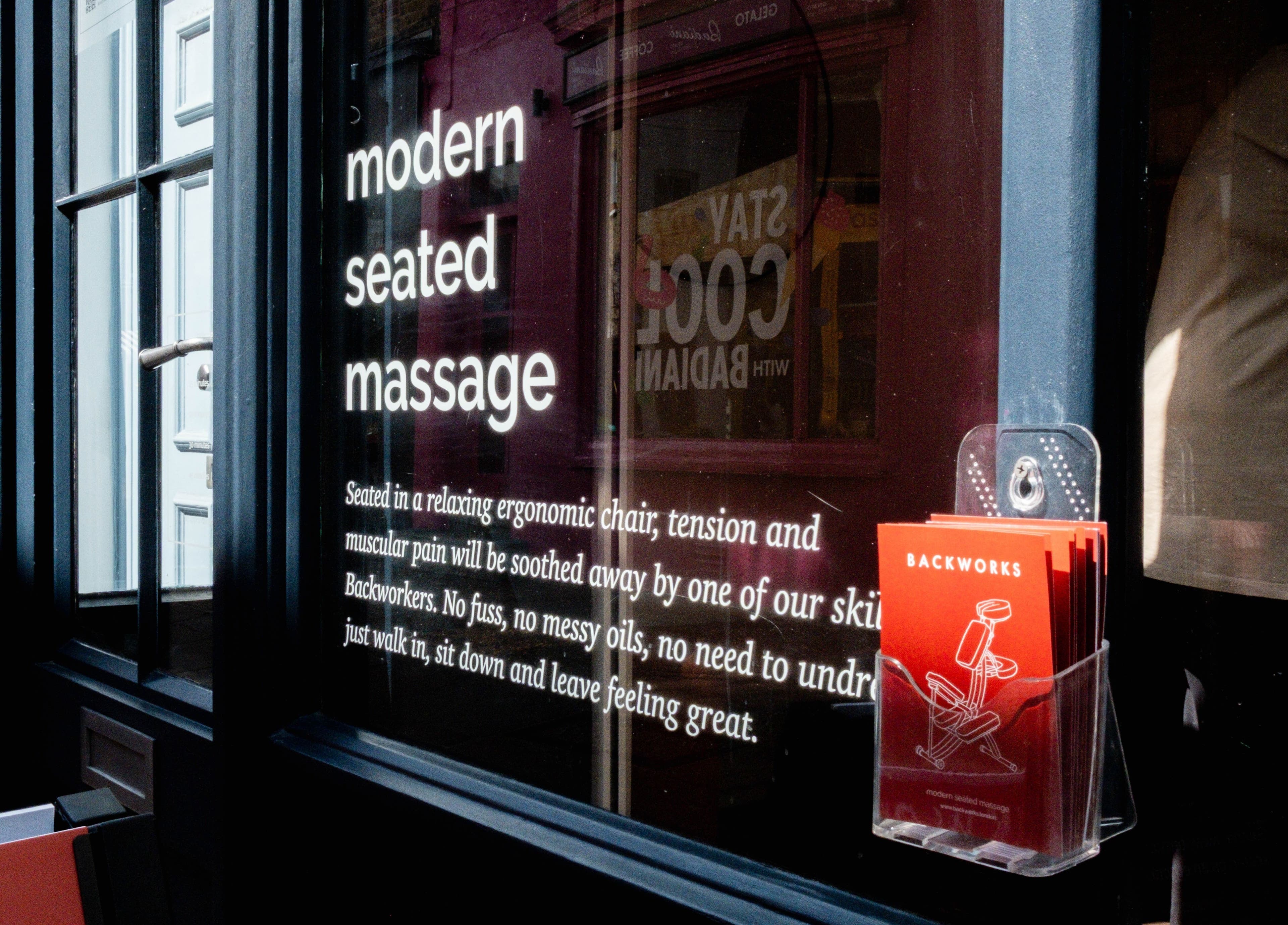 Modern seated massage sign at X+Why at One Great Cumberland Place, London, England, GB.