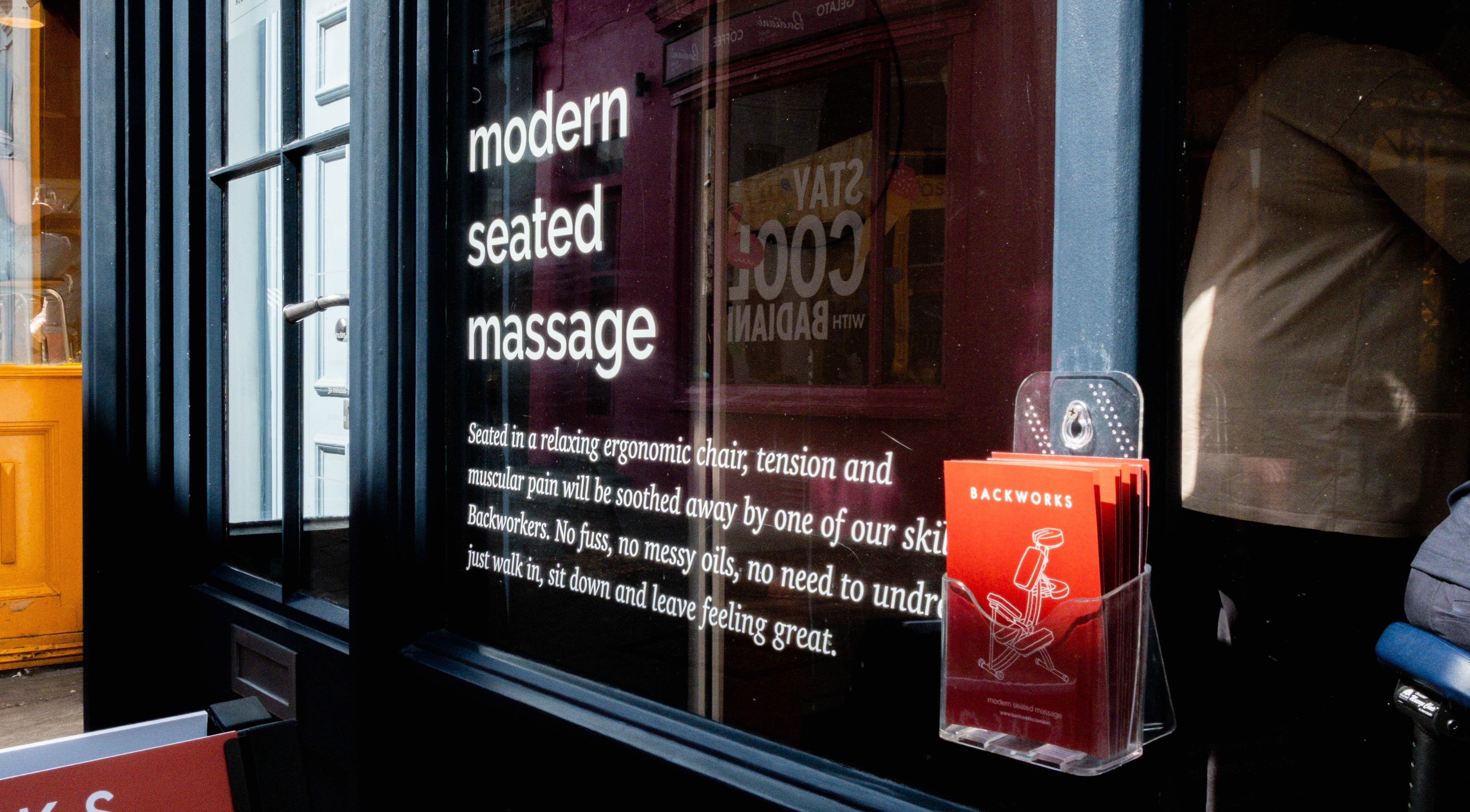 Modern seated massage sign at X+Why at One Great Cumberland Place, London, England, GB.