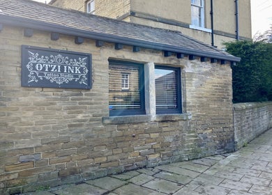 Exterior of Otzi Ink tattoo studio, a rustic stone building in Shipley, England, GB.