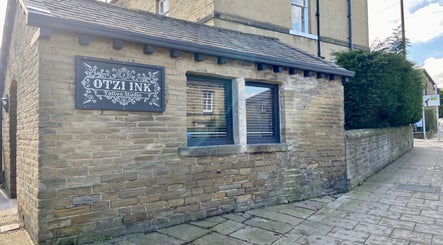 Exterior of Otzi Ink tattoo studio, a rustic stone building in Shipley, England, GB.