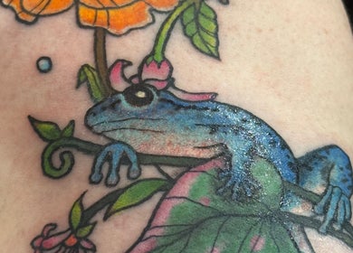 Colorful frog tattoo artwork displayed at Otzi Ink, Shipley, England, GB highlighting expert ink techniques.