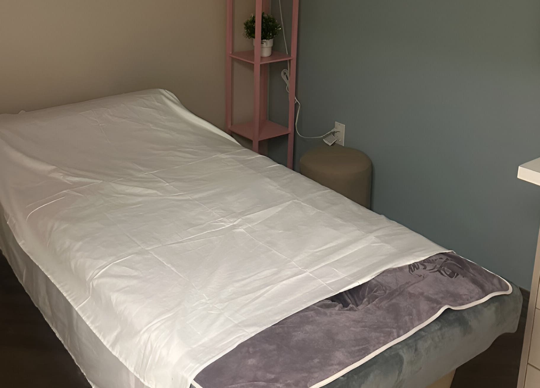 Calm massage room at Pattaya Spa, Pembroke Pines, Florida, US with a neatly made treatment bed.