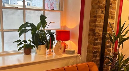 Warm interior with plants and orange lamp at Alexia Constantin Beauty, Hereford, England, GB.