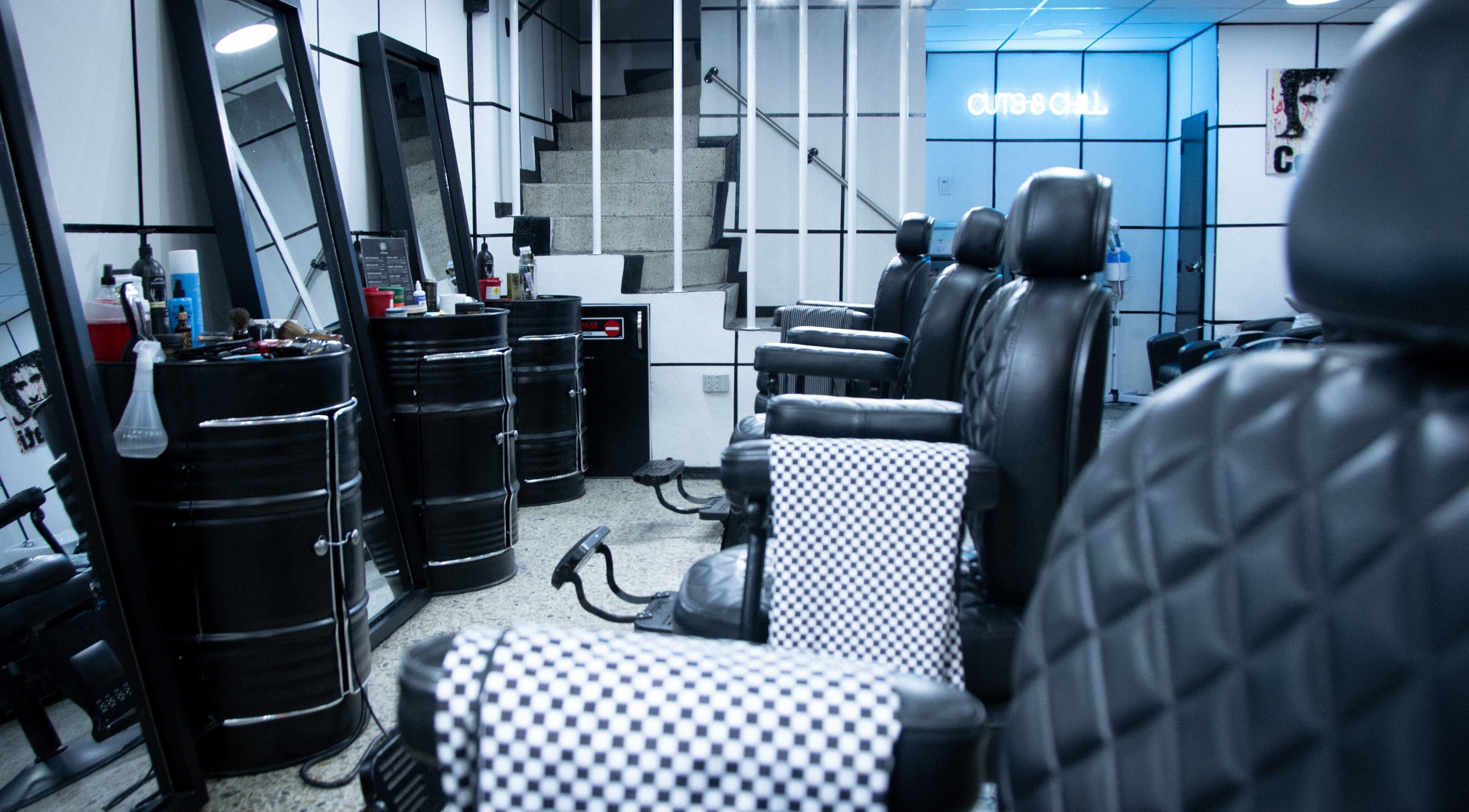 Interior moderno de All Handmade Barbería en Bogotá, Cundinamarca, CO con sillas elegantes y decoración estilizada.