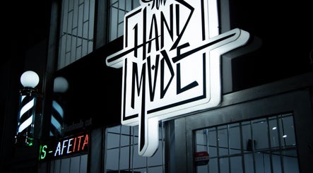 Cartel iluminado de All Handmade Barbería en Bogotá, Cundinamarca, CO, mostrando estilo moderno.
