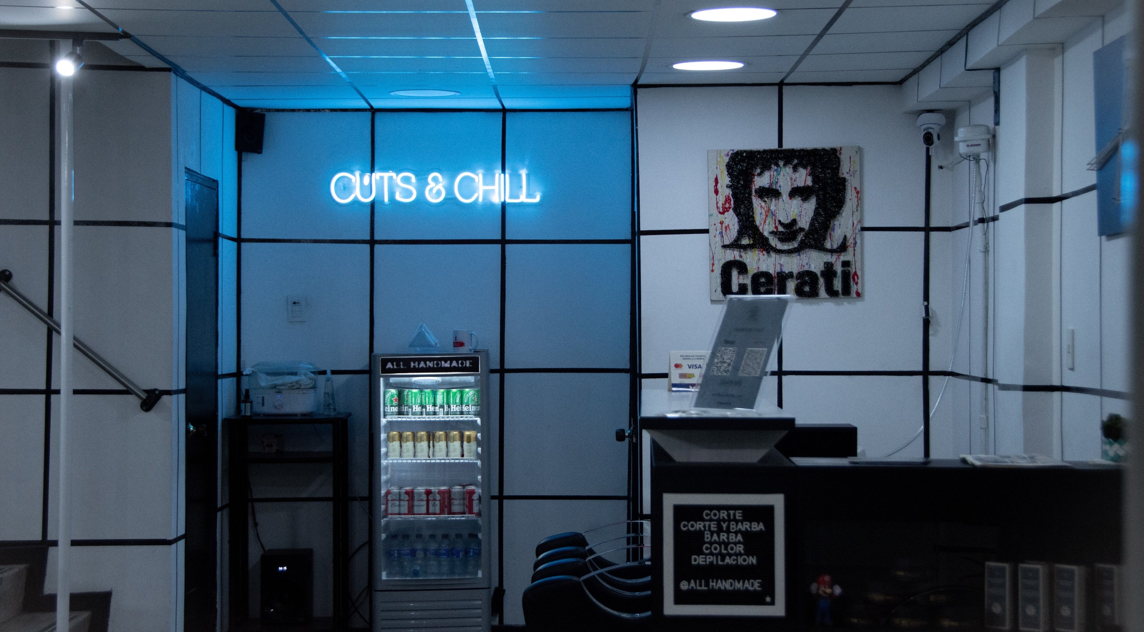 Interior de All Handmade Barbería en Bogotá, Cundinamarca, CO mostrando cartel 'Cuts & Chill' y nevera.