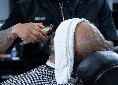 Barbero en All Handmade Barbería Bogotá, Cundinamarca, CO, aplicando aceite en barba de cliente.