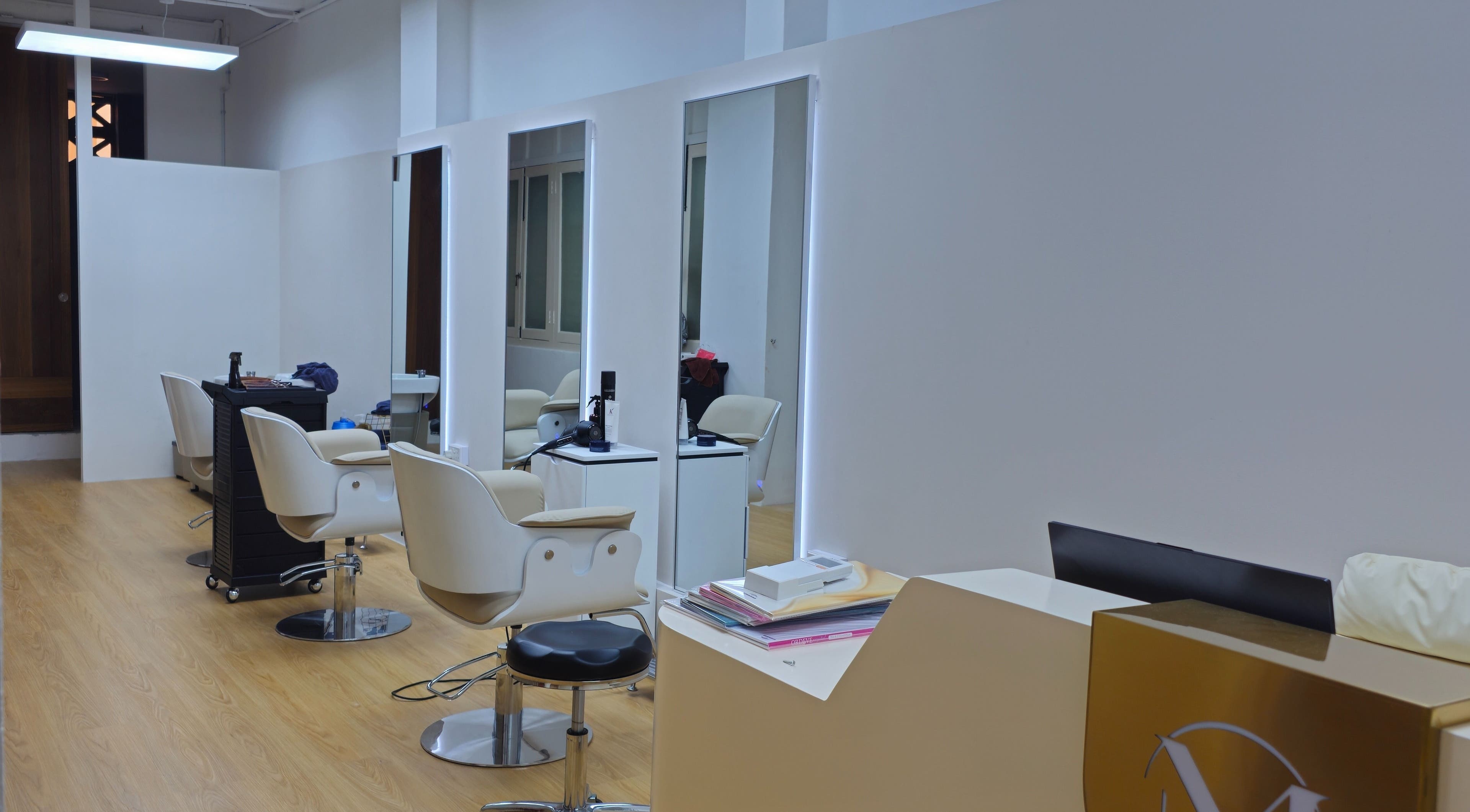 Modern salon interior at M.Y Refresh HairLab, Singapore, SG, featuring stylish chairs and mirrors.