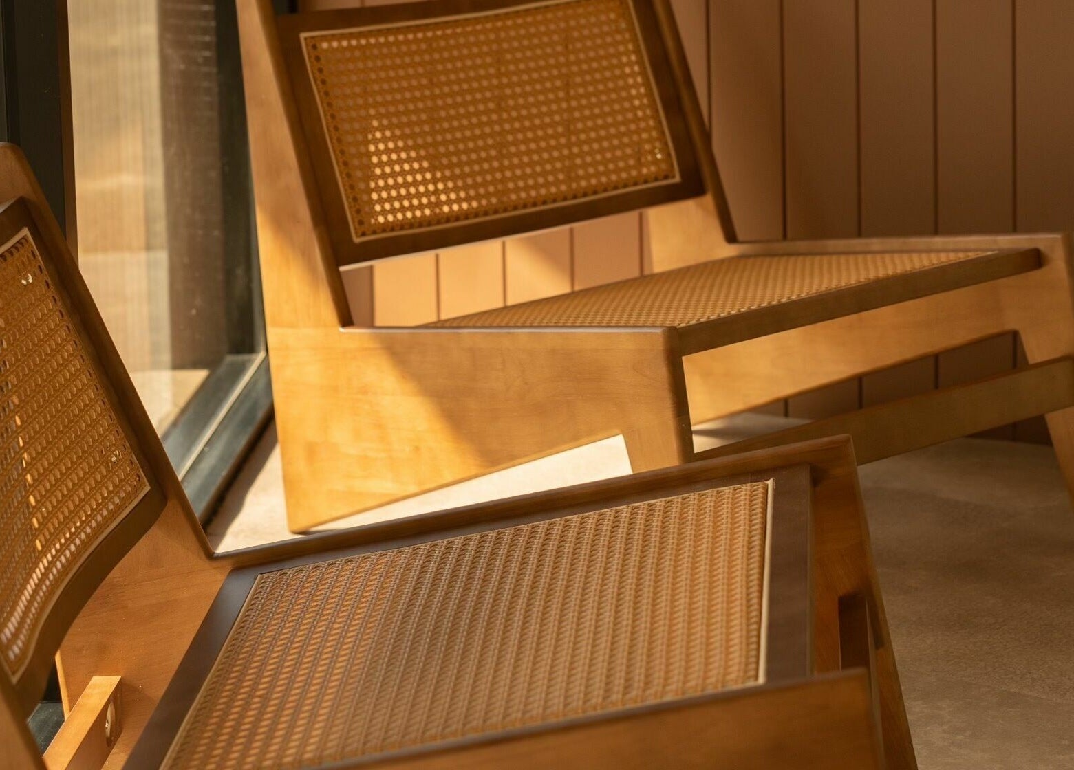 Cozy wooden lounge chairs in sunlight at Aura Sweat, Thirroul, New South Wales, AU. Ideal for relaxation and wellness.