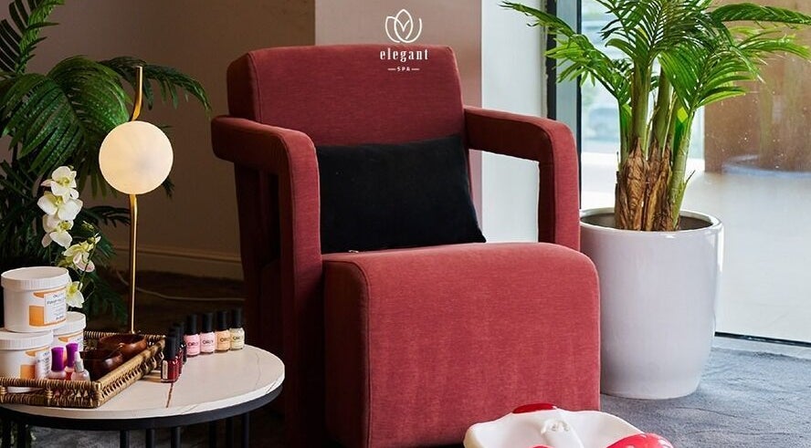 زاوية هادئة في Elegant Spa | ايلقنت سبا للخدمات المنزلية، الرياض، توفر كرسي مريح وزهور وفوانيس هادئة.