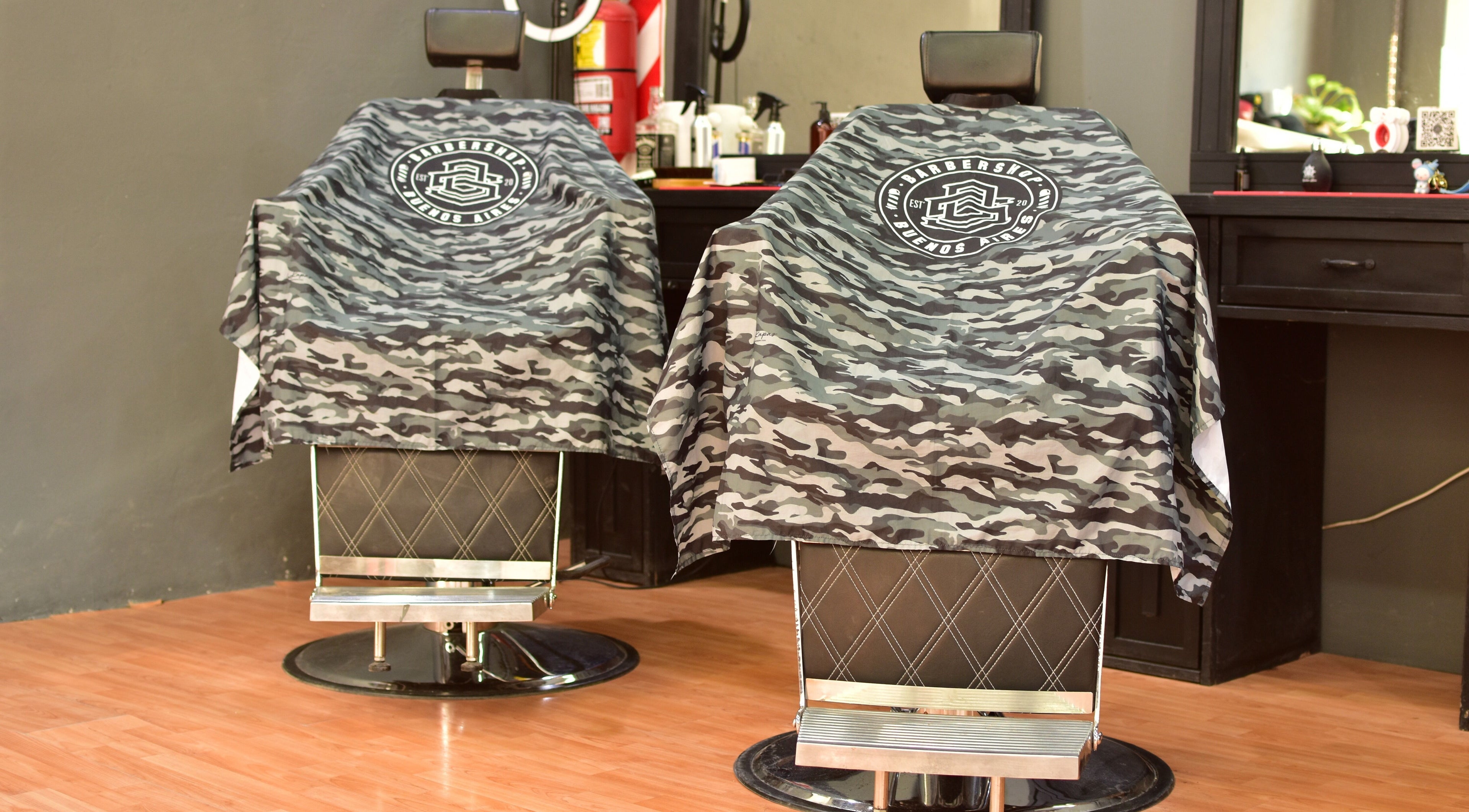 Sillas de barbero en DS Barbershop, Buenos Aires, con cobertores camuflados únicos y estilo moderno.
