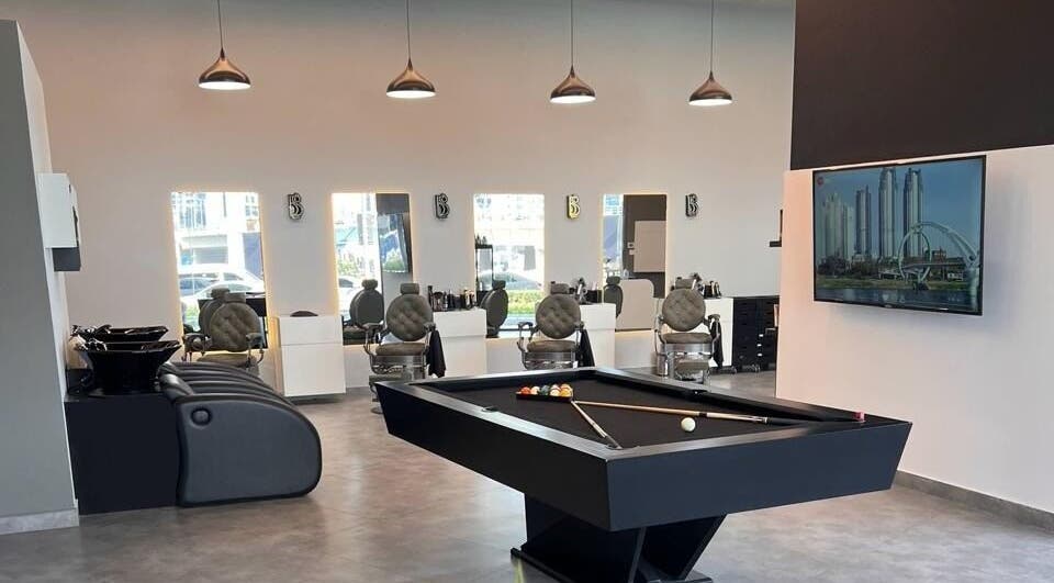 Modern interior of Barber Bliss L.L.C in Dubai, Dubai, AE featuring stylish barber chairs and a pool table.