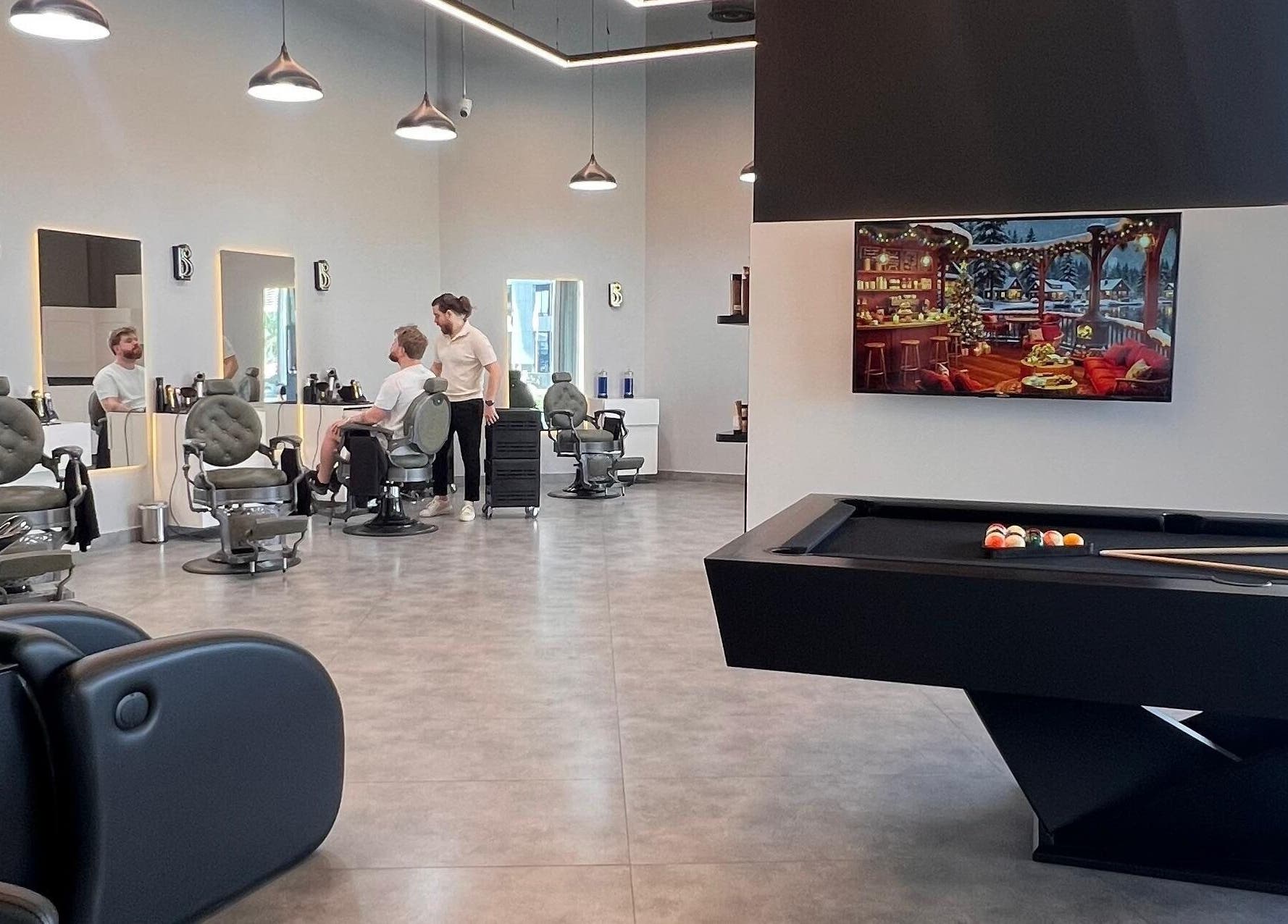Modern interior of Barber Bliss L.L.C in Dubai, Dubai, AE, featuring stylish chairs and a pool table.