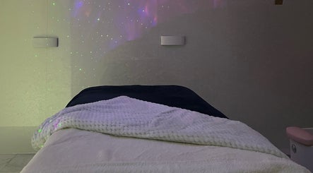 Relaxing treatment room at Hushed Beauty, Glasgow, Scotland, GB with star-like lighting and cozy blankets.