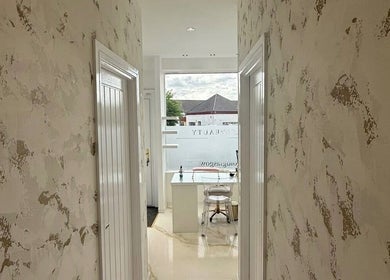 Bright corridor at Hushed Beauty, Glasgow, Scotland, GB, leading to a chic, well-lit beauty station.
