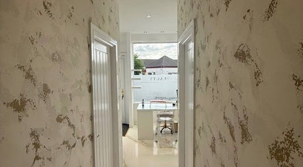 Bright corridor at Hushed Beauty, Glasgow, Scotland, GB, leading to a chic, well-lit beauty station.