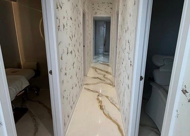 Marbled corridor at Hushed Beauty, Glasgow, Scotland, GB, leading to a tranquil treatment room.