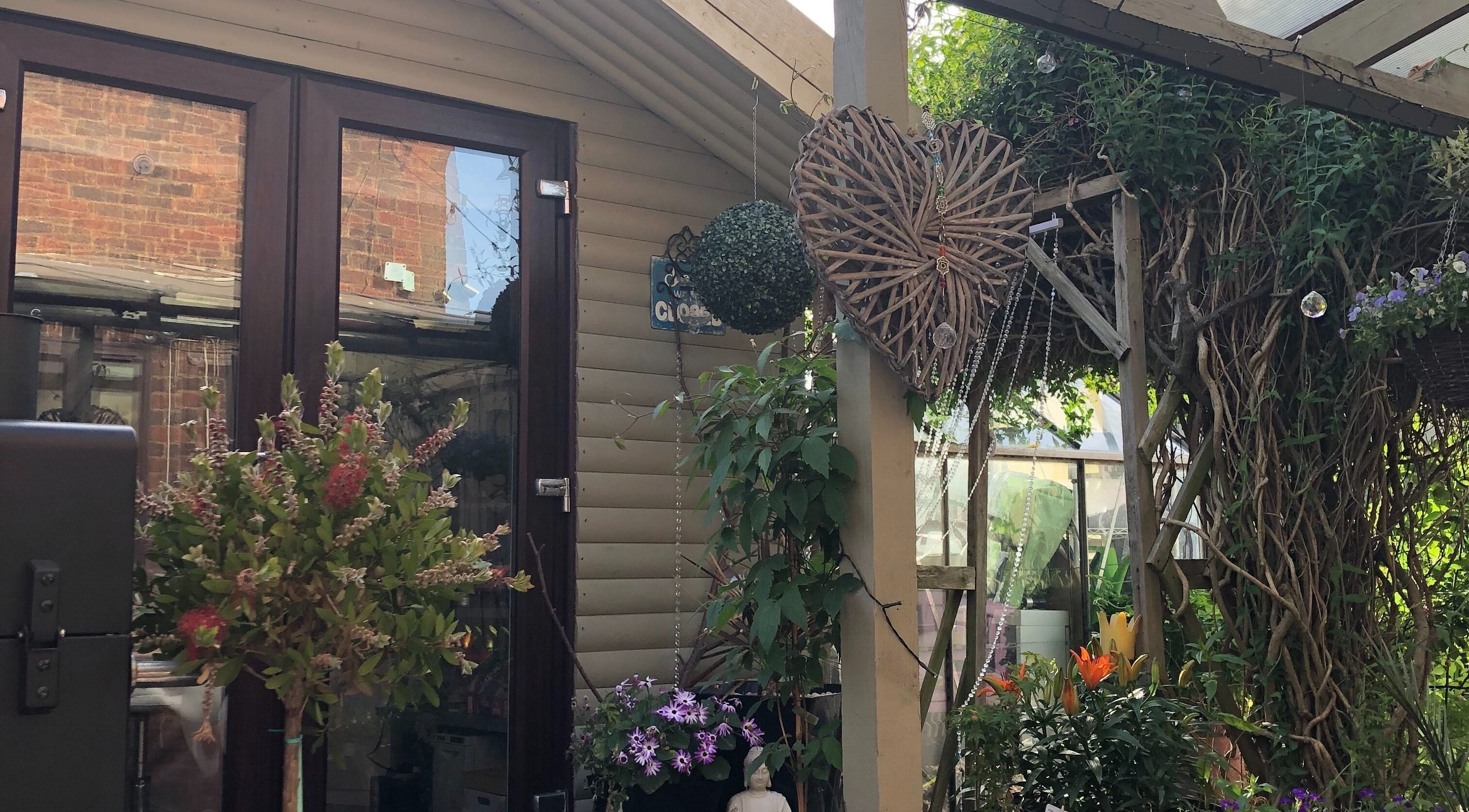 Lush garden at Luna Rose Holistic & Beauty Therapy, Loughborough, England, GB, featuring vibrant plants and decor.
