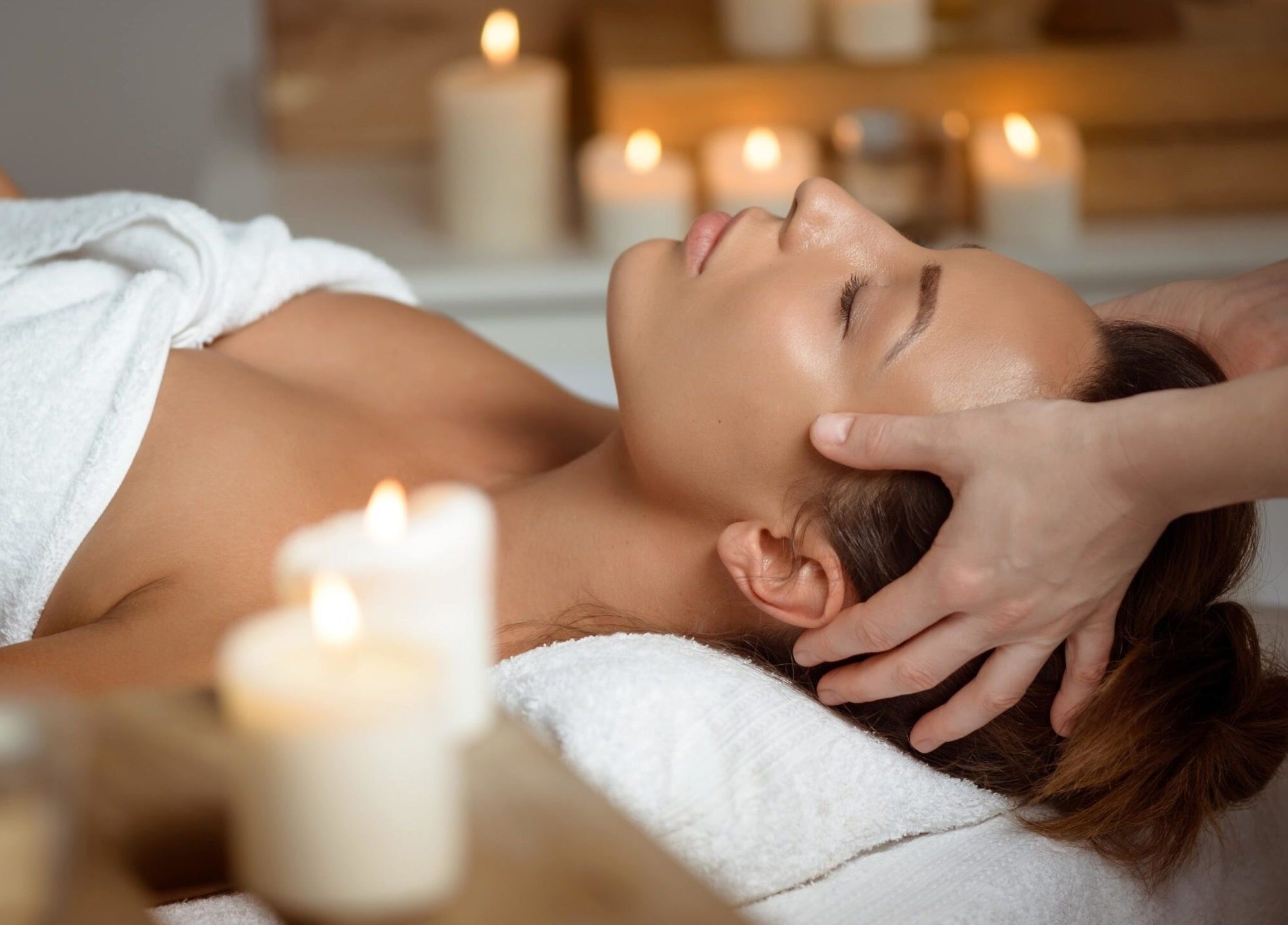 Luxurious head massage at Luna Rose Holistic Therapy, Loughborough, England, GB amidst glowing candlelight.