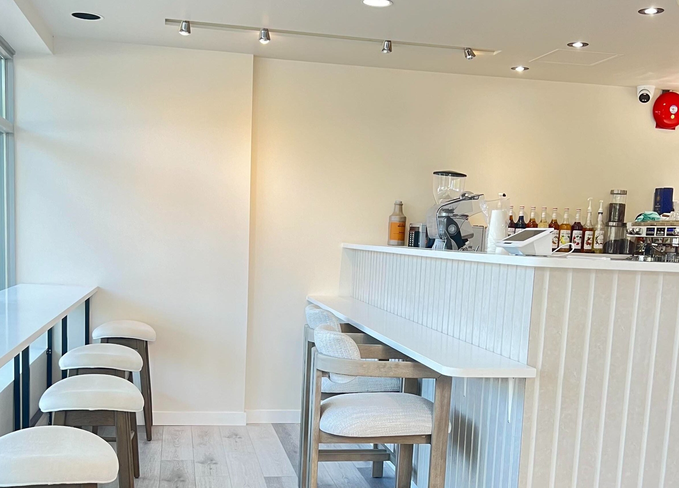 Interior of Artesano Cafe and Nail in Vancouver, BC, with bar stools and a modern counter area.