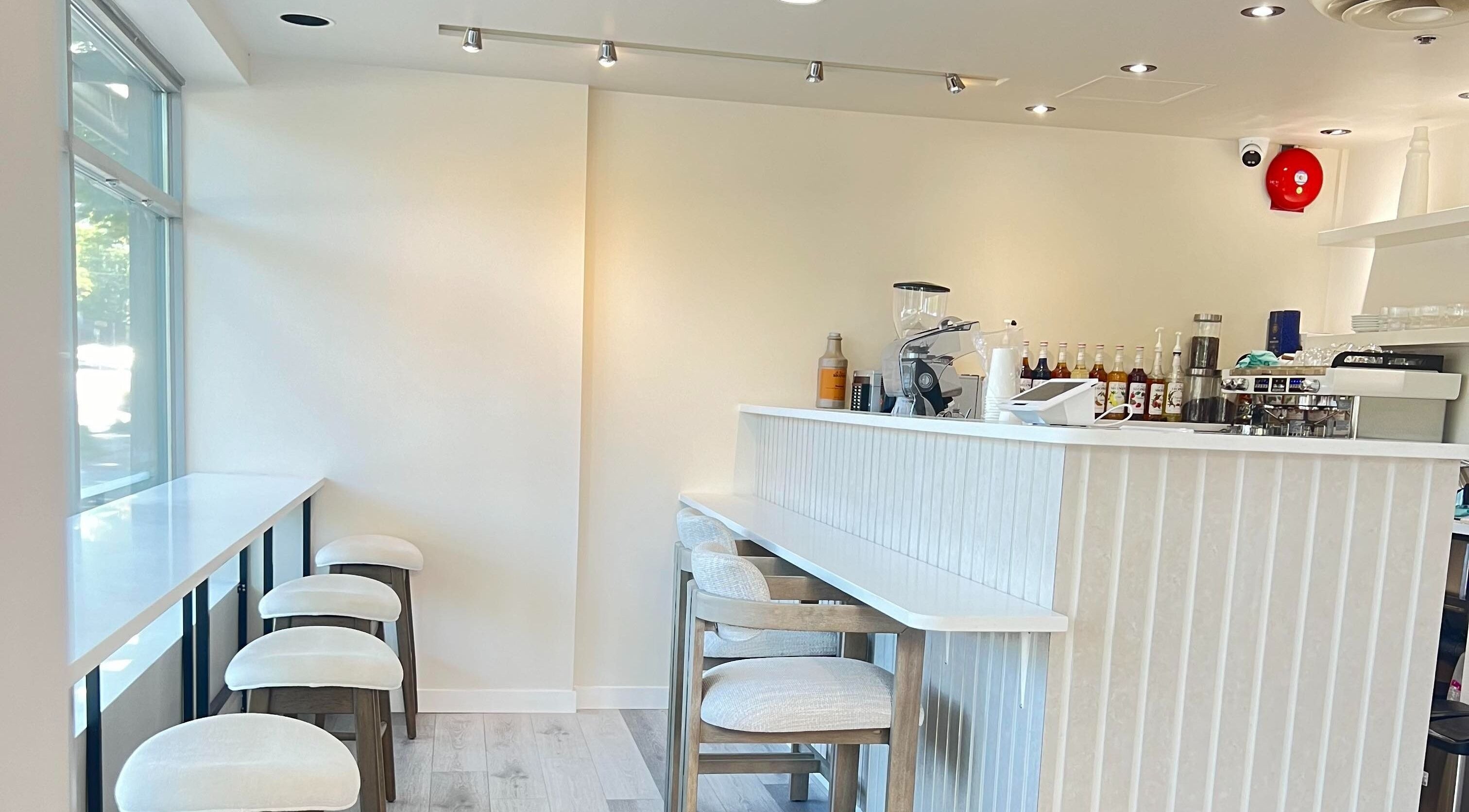 Interior of Artesano Cafe and Nail in Vancouver, BC, with bar stools and a modern counter area.