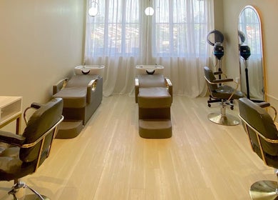Elegant salon interior at Aurora Muslimah Salon & Spa Bangsar, Kuala Lumpur, featuring stylish chairs and mirrors.