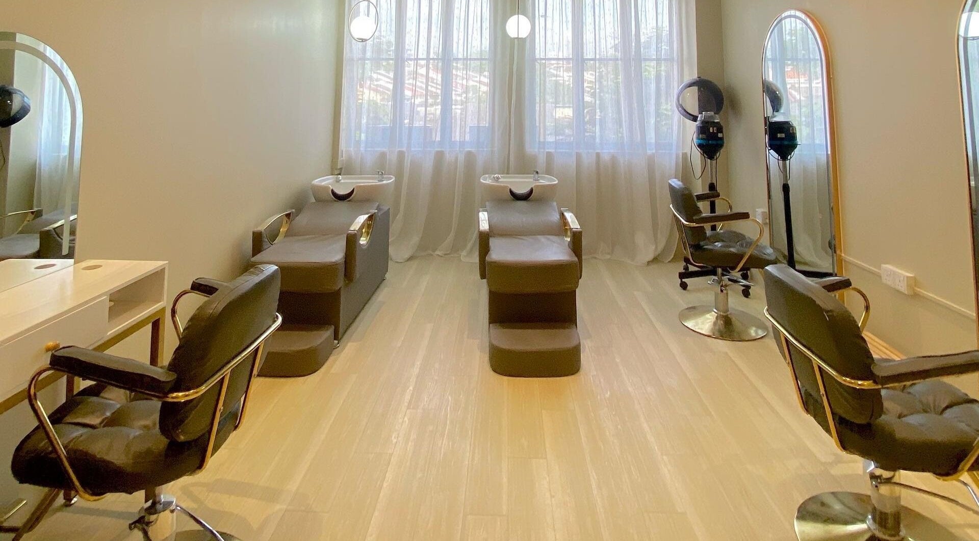 Elegant salon interior at Aurora Muslimah Salon & Spa Bangsar, Kuala Lumpur, featuring stylish chairs and mirrors.