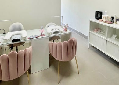 Interior do estúdio BT Nails e Estética em Lisboa, Lisboa, PT com cadeiras rosa e mesa de manicure.