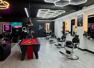 Modern interior of Razortrim in Birmingham, England, GB featuring sleek barber chairs and vibrant decor.