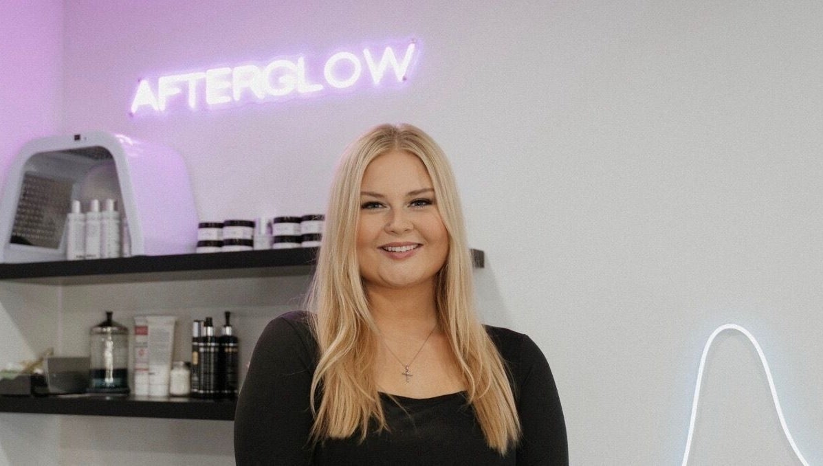 Smiling professional at Audreys Afterglow Esthetics and Permanent Cosmetics, Jackson, Ohio, US with beauty products.