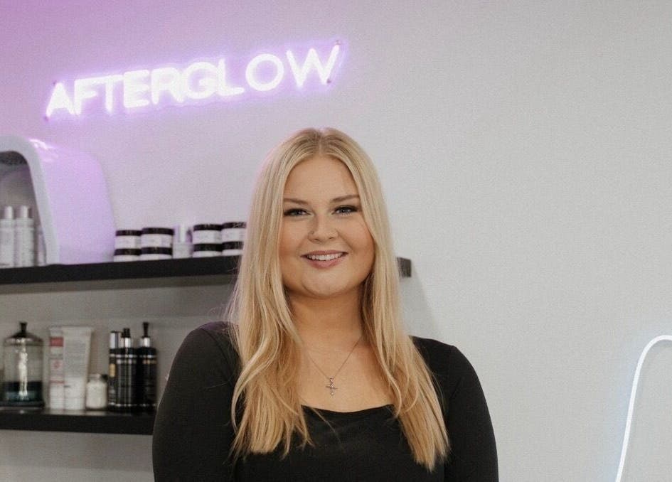 Smiling professional at Audreys Afterglow Esthetics and Permanent Cosmetics, Jackson, Ohio, US with beauty products.