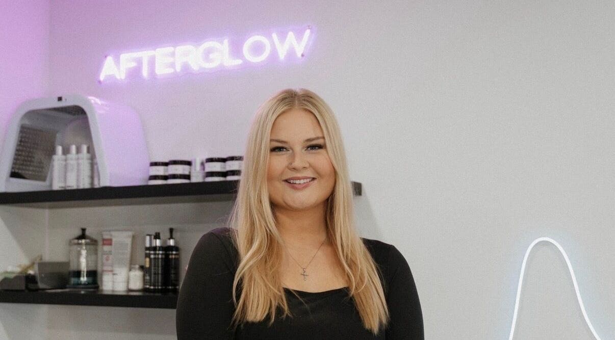 Smiling professional at Audreys Afterglow Esthetics and Permanent Cosmetics, Jackson, Ohio, US with beauty products.