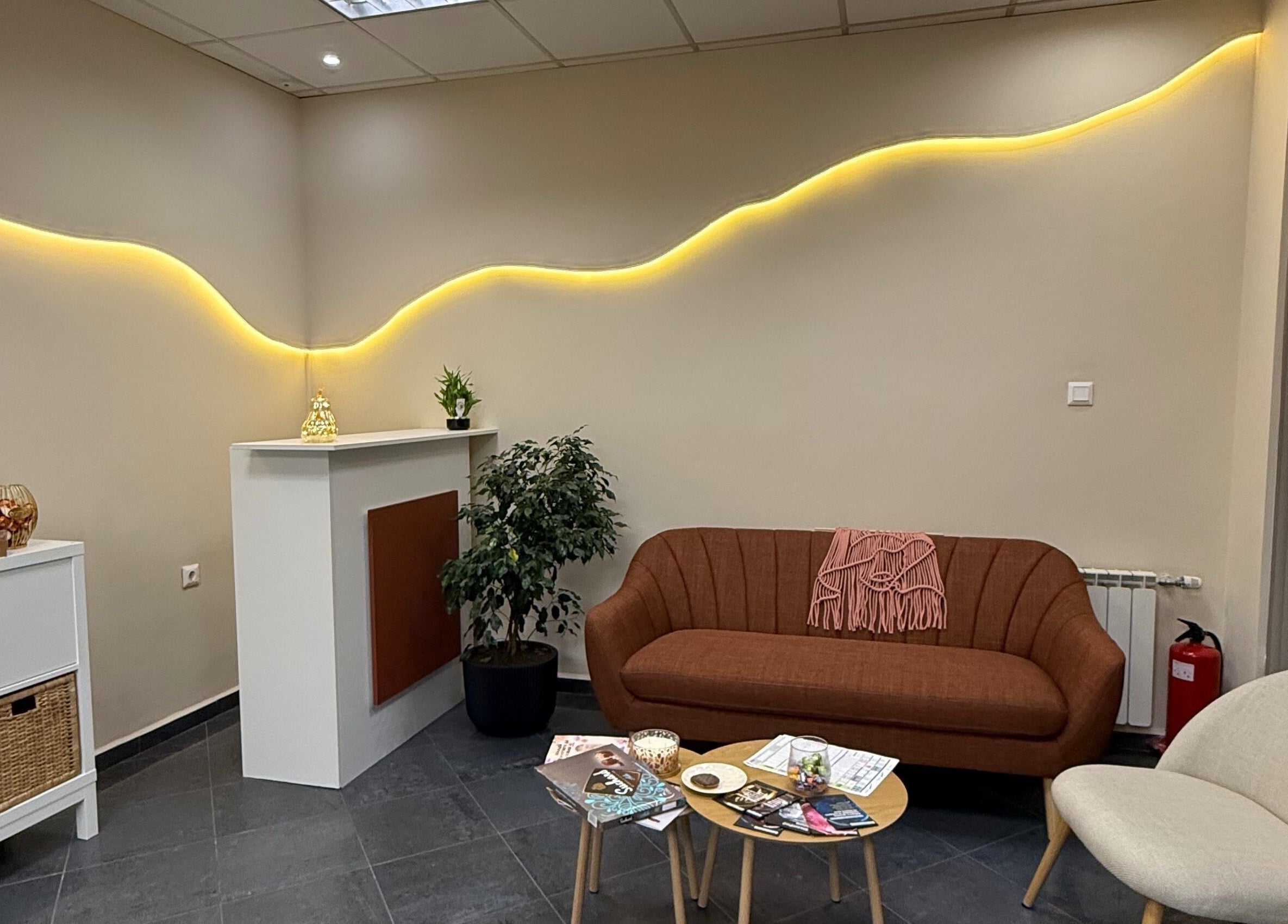 Модерен кът за изчакване в Milenails, София, Софийска област, BG с удобен диван и растения.