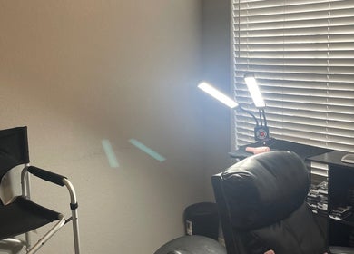 Cozy makeup station at Enhanced Beauty in Florida, Florida, US with chairs, lighting, and makeup tools.