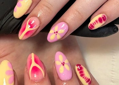 Colorful floral nail designs at Nailsby.S.B, Worthing, England, GB. A blend of pink and yellow accents.