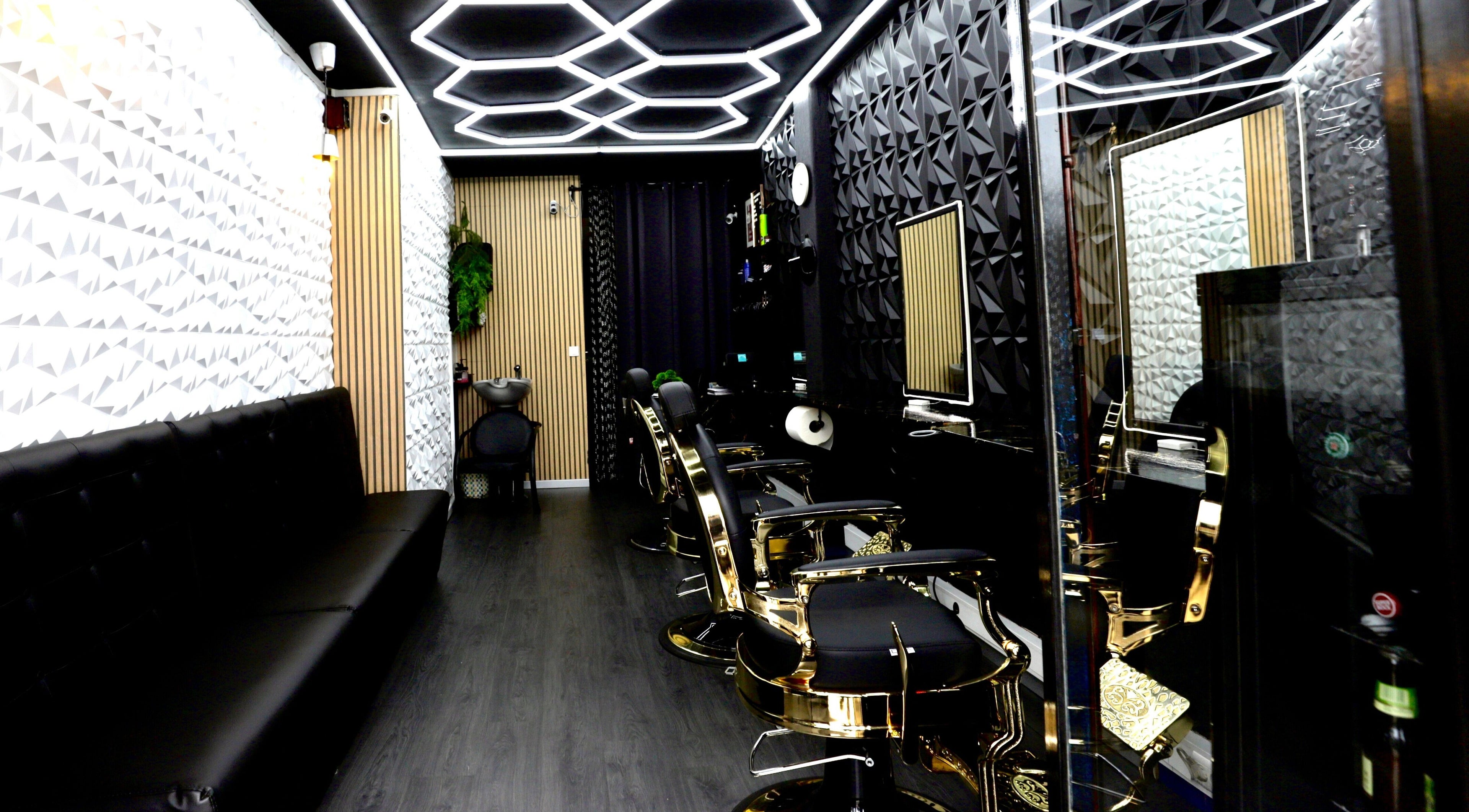 Interior of Sirius Barbershop Rato in Lisboa, PT, featuring sleek black and gold barber chairs and modern design.