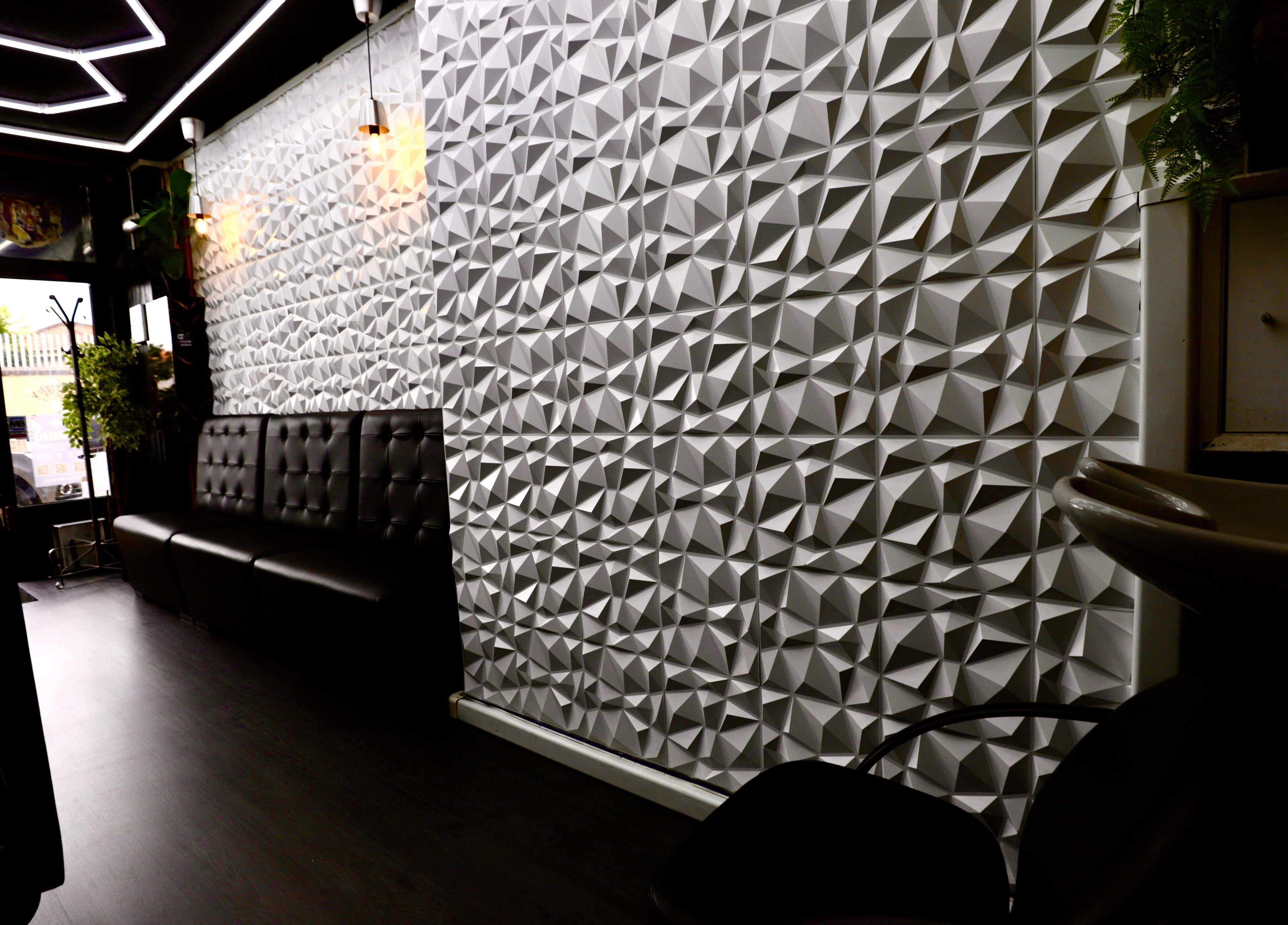 Chic interior of Sirius Barbershop Rato in Lisboa, Lisboa, PT with geometric walls and sleek seating.