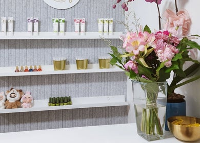 Elegant shelves at Vanity Nail Studio, Richmond, BC, CA, showcasing beauty products and flowers.