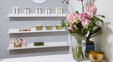 Elegant shelves at Vanity Nail Studio, Richmond, BC, CA, showcasing beauty products and flowers.