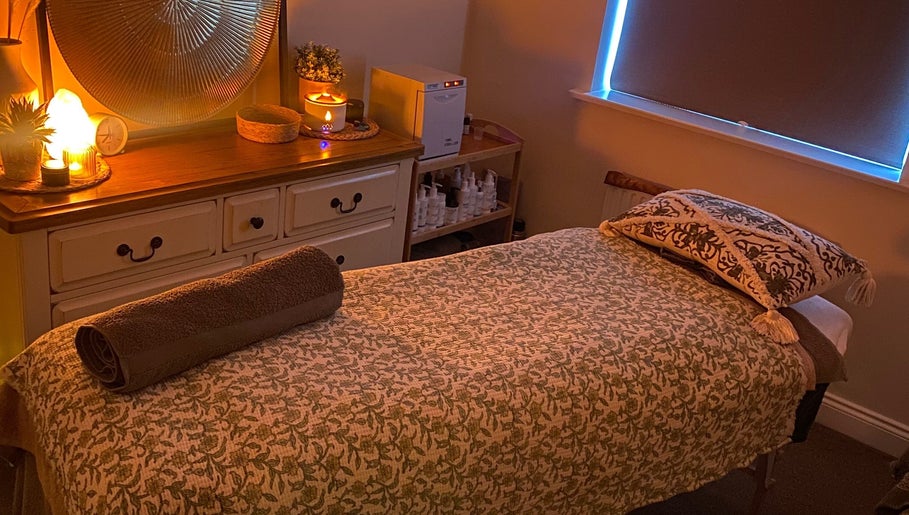 Cozy massage room at Soothing Senses, Thrapston, England, GB, featuring warm lighting and a comfortable massage table.