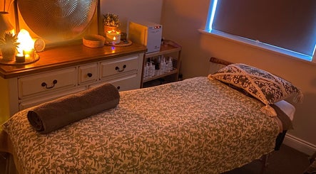 Cozy massage room at Soothing Senses, Thrapston, England, GB, featuring warm lighting and a comfortable massage table.
