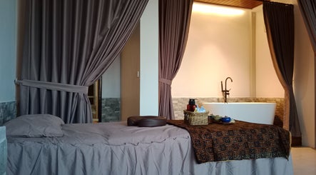 Relaxing spa room at Putri Beauty and SPA Seminyak, Bali, ID featuring a massage bed and elegant decor.
