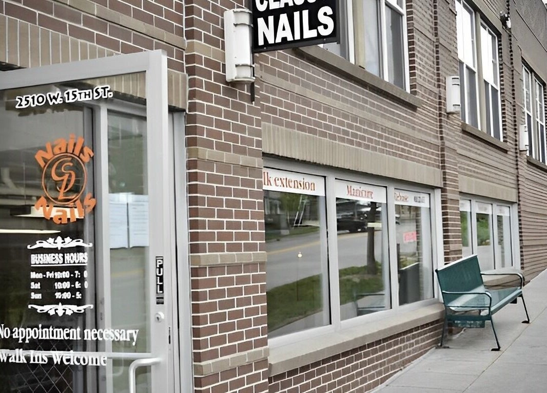 Entrance to Classy Nails in Denver, Colorado with welcoming sign and modern brick exterior.