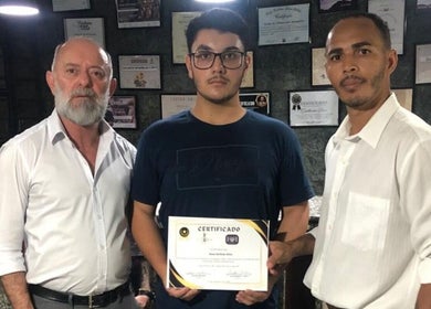 Três homens orgulhosos exibem certificado na Barber House, São Paulo, São Paulo, BR.