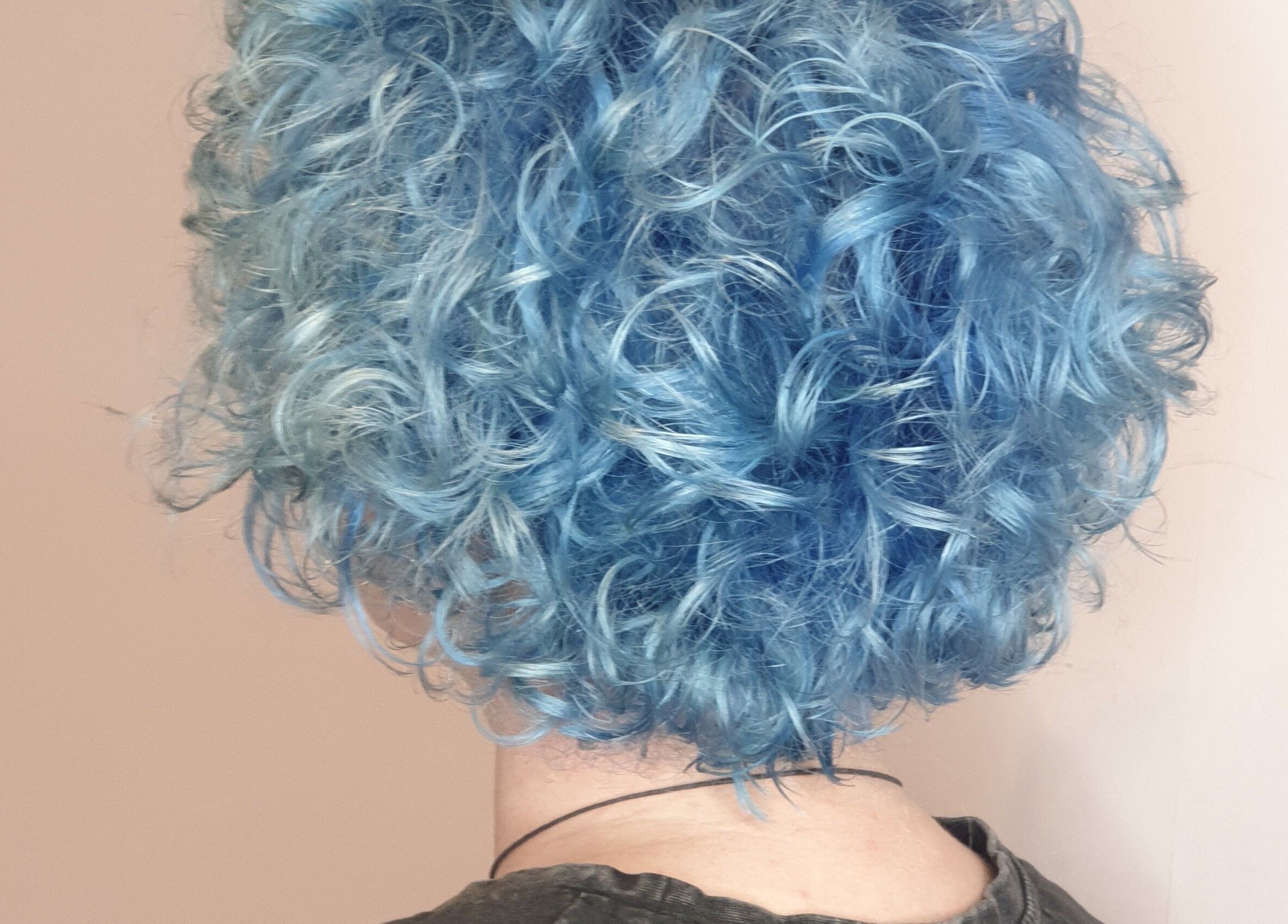 Vibrant blue curls hairstyle at Louise Frances in Derby, England, GB. Showcasing expert hairdressing skills.